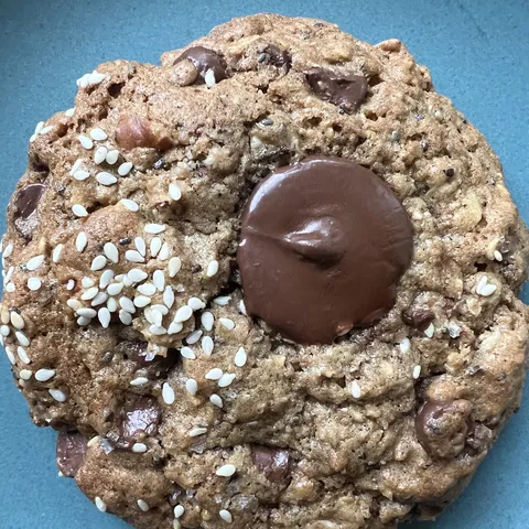 The breakfast cookie, topped with sesame and a chocolate button.