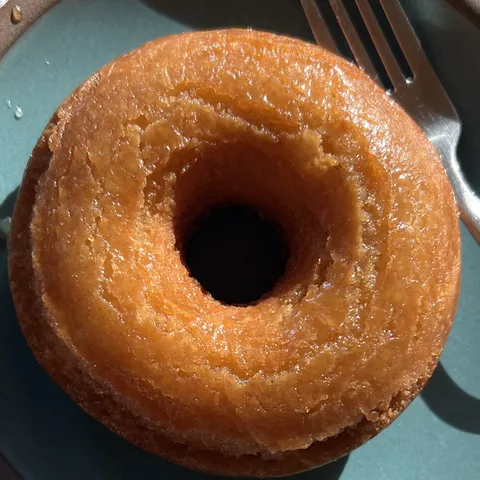 A glazed cake doughnut on a stoneware plate.