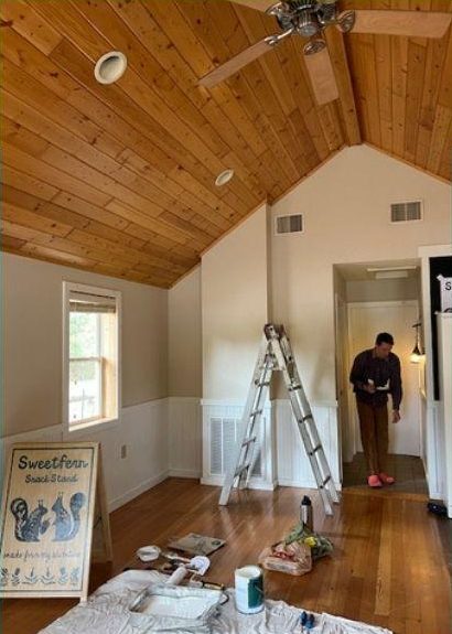 Inside the future shack: a ladder, paint, and the market sign against the wall.