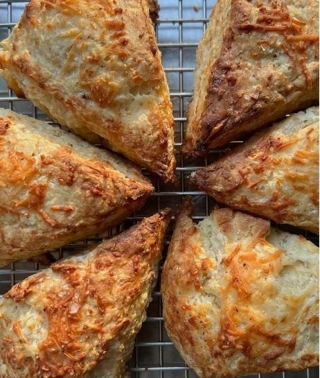 Cheddar and herb scones on a cooling rack.