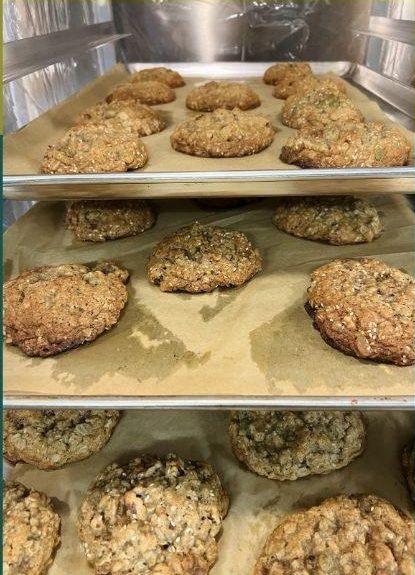Sheet pans of granola cookies on a cooling rack.